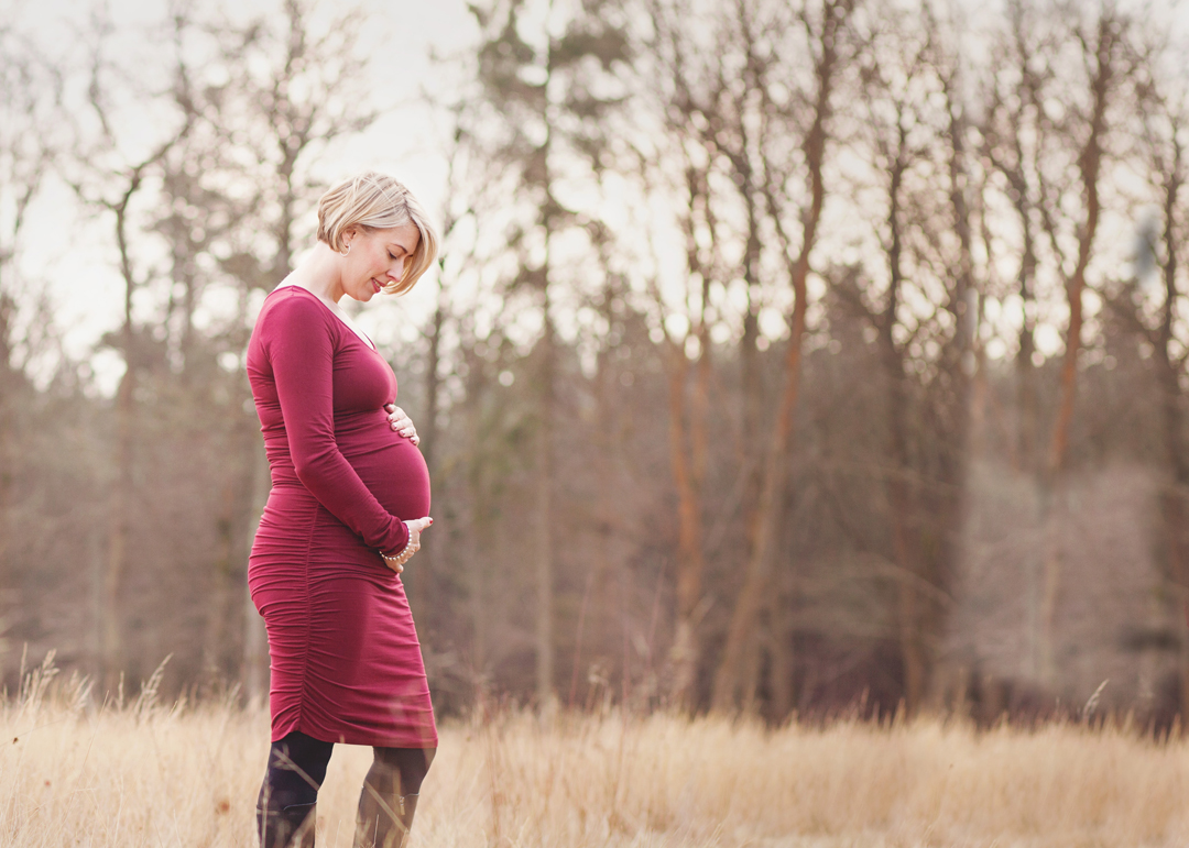 Maternity photograph of mother wearing pale pink gown in the New Forest