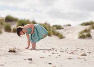 Photograph of girl collecting shells on West Wittering beach by Moira Lizzie Photography
