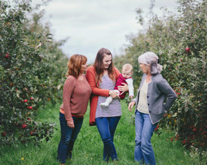 Autumnal image of four generations of women set in apple orchard
