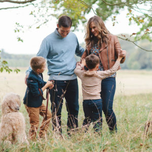 Outdoor portrait image of family of four with dog