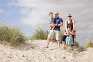 Photograph of family in sand dune at West Wittering Beach by Moira Lizzie Photography