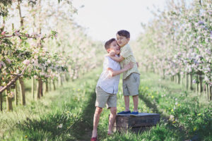 Brothers in apple orchard by Moira Lizzie Photography