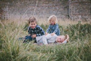 Three siblings playing outside Portchester Castle by Moira Lizzie Photography