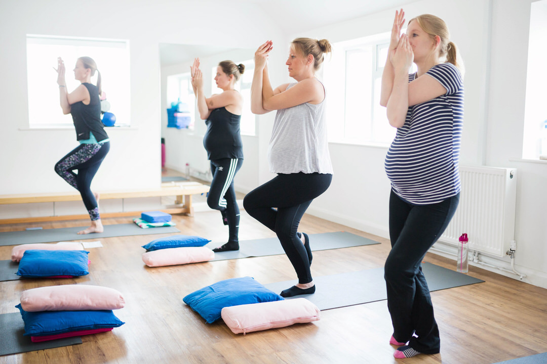 Pregnancy yoga class attendees pose
