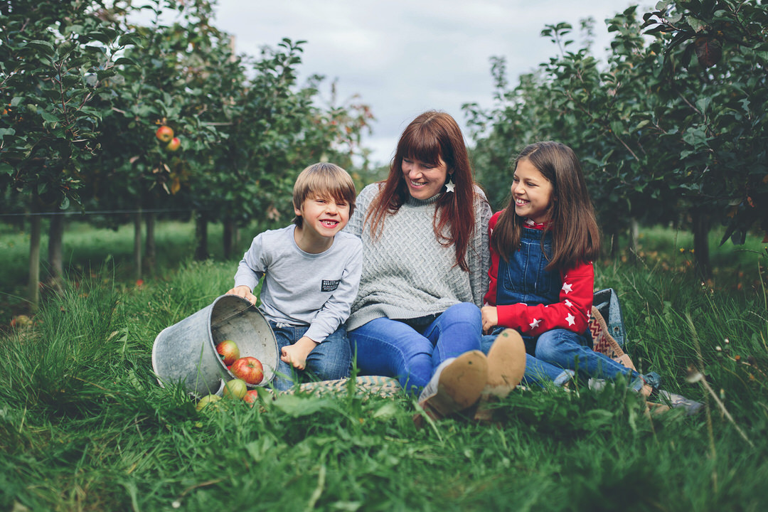 Autumn portrait of family of 3 set in apple orchard by Moira Lizzie photography